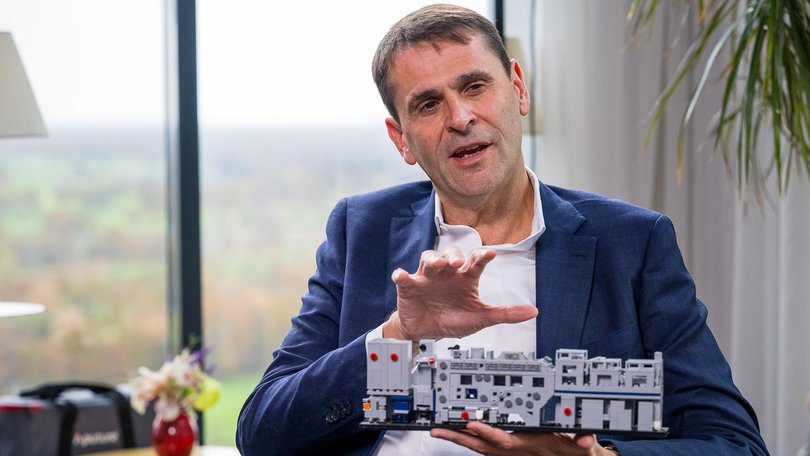 Christophe Fouquet, chief executive officer of ASML Holding NV, holds a model of a semiconductor lithography machine.