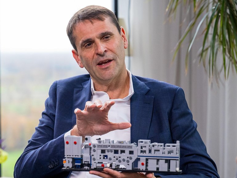 Christophe Fouquet, chief executive officer of ASML Holding NV, holds a model of a semiconductor lithography machine.