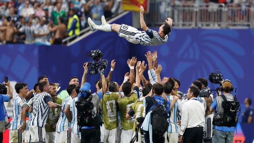 Argentina players celebrate their dramatic victory by tossing Lionel Messi into the air in Atlanta.