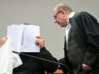 The defendant covering his face in Munich in February as he arrives for a trial against a network of men accused of using chat groups to share tips on how to drug and rape women.