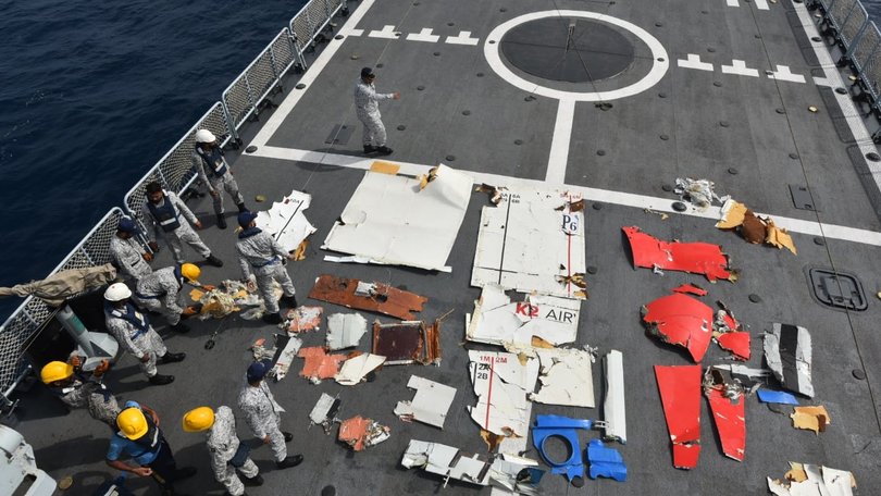 Red and white debris with the words “K2 Air” laid out on the ship’s deck.