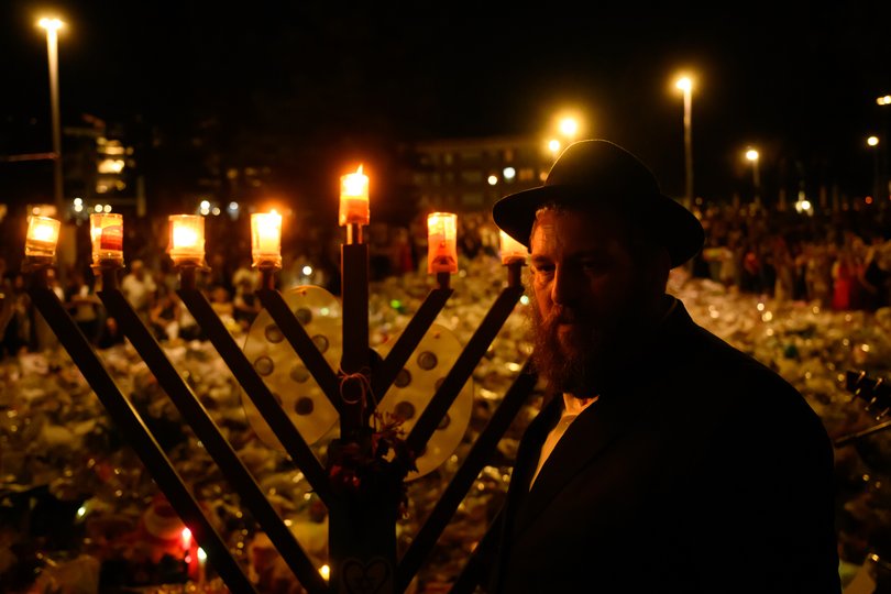 A rabbi ignites the menorah during the vigil at the memorial at Bondi Pavilion at Bondi Beach on December 20, 2025.