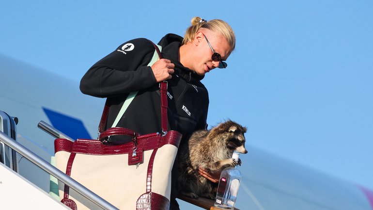 Norway’s Erling Haaland gets off the plane with a stuffed raccoon.
