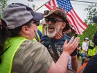 A pro-ICE counter-protester yells at an anti-ICE protester during a demonstration after a man was fatally shot by ICE.