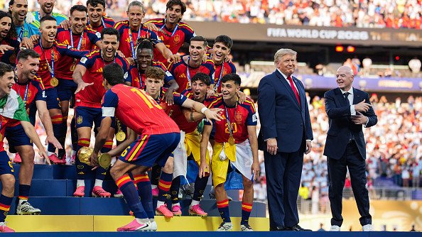US President Donald Trump and FIFA President Gianni Infantino stand on stage as Rodri #9 of Spain raises the FIFA World Cup Winner’s Trophy.
