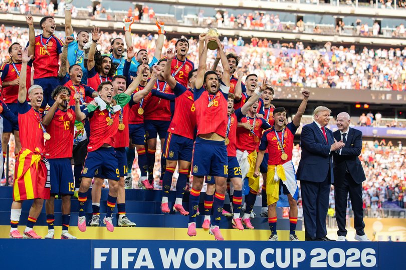US President Donald Trump and FIFA President Gianni Infantino stand on stage as Rodri #9 of Spain raises the FIFA World Cup Winner’s Trophy.