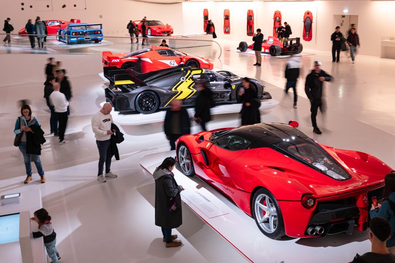 Visitors look at cars on display at the Ferrari Museum in Modena, Italy.