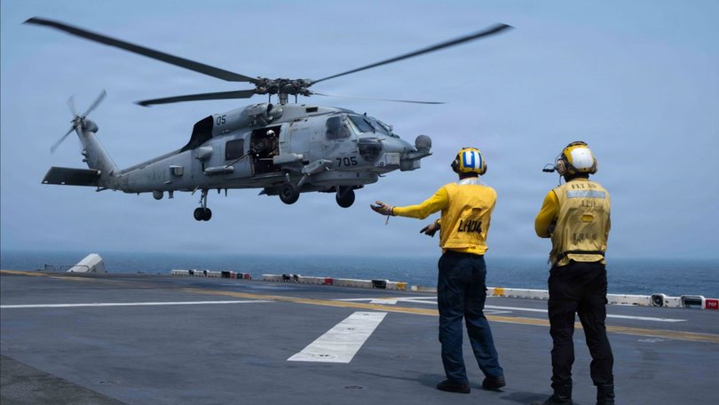 US service members aboard amphibious assault ship USS Boxer support flight operations as CENTCOM enforces the naval blockade against Iran.