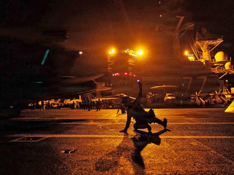 US Sailors signal an F/A-18E Super Hornet on the deck of USS George H.W. Bush in the Arabian Sea.