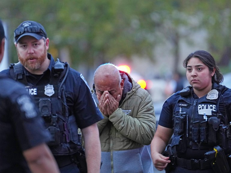 An unidentified man is led into the scene by police after they responded to a shooting at Seattle Center during the Bite of Seattle food festival Sunday, July 26, 2026, in Seattle, Washington.