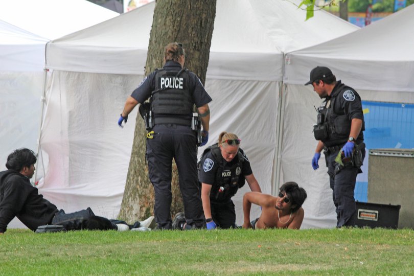 Police attend to a person after a shooting at Seattle Center during the Bite of Seattle food festival on Sunday.