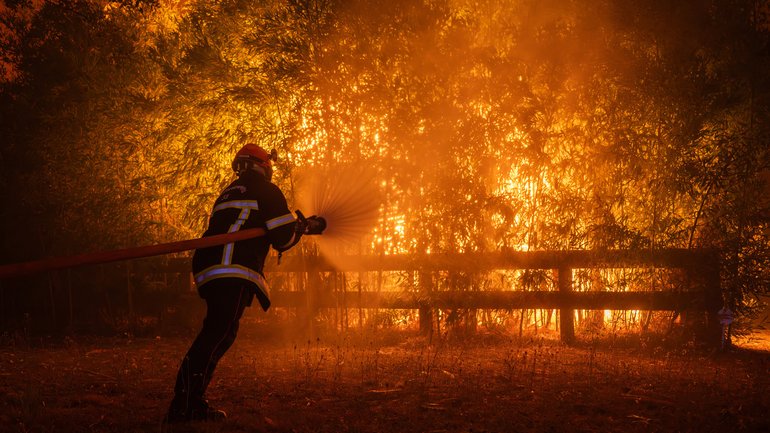 A firefighting crew battles a wildfire spreading in Ares, south-western France.