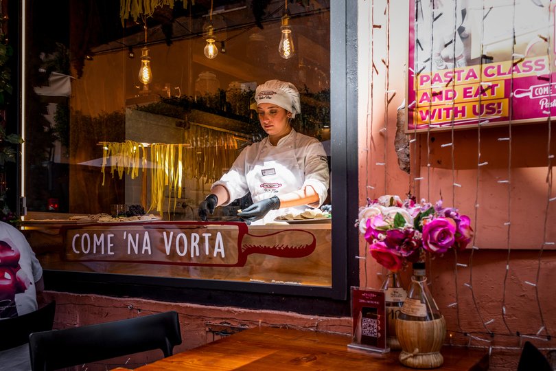 A pasta-maker works in the window of the Rome restaurant Come 'Na Vorta.