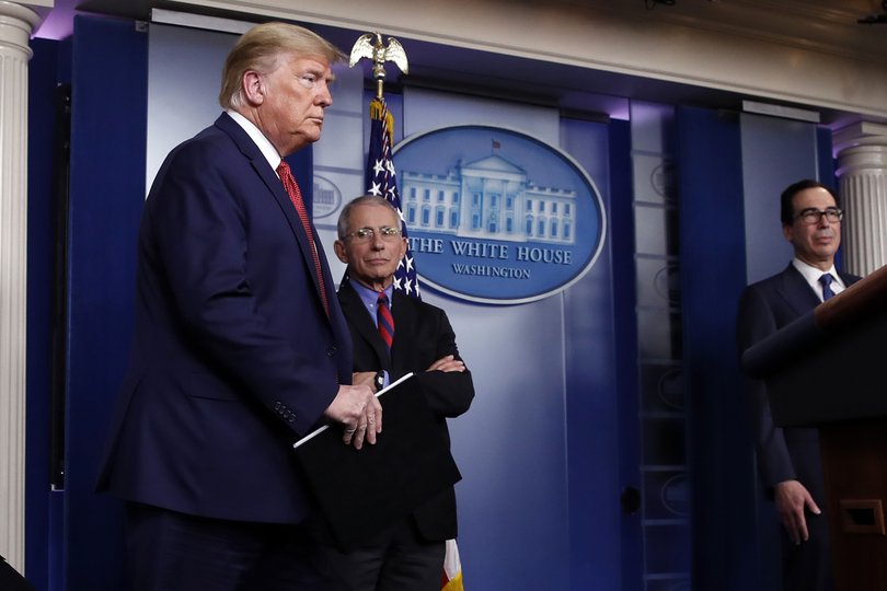 President Donald Trump arrives to speak about the coronavirus in the James Brady Briefing Room, Wednesday, March 25, 2020, in Washington. Watching are Dr. Anthony Fauci, director of the National Institute of Allergy and Infectious Diseases, and Treasury Secretary Steven Mnuchin.