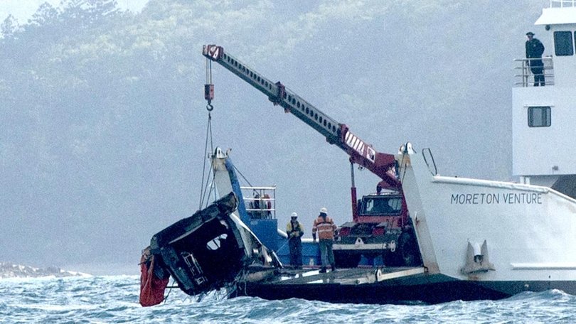 A barge anchored at the site where a MRH 90 Taipan military helicopter crashed, lifts out the tail section. in the Whitsundays while carrying four Australians. Picture: Michaela Harlow