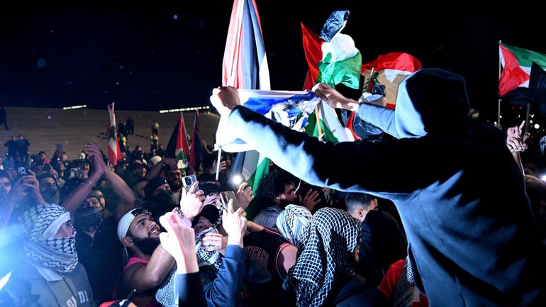 Participants of a Free Palestine rally desecrate an Israeli flag outside the Sydney Opera House on October 9, 2023.
