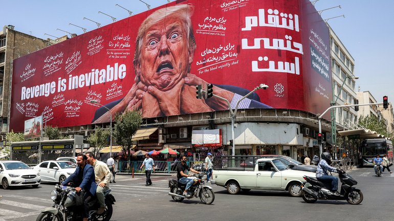 Motorists drive past a large billboard pledging revenge against US President Donald Trump along Jomhouri Street in central Tehran.