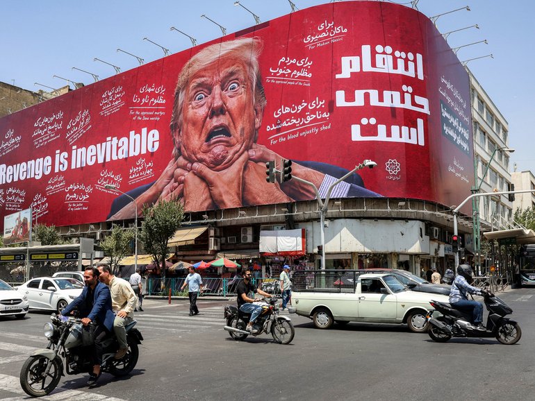 Motorists drive past a large billboard pledging revenge against US President Donald Trump along Jomhouri Street in central Tehran.