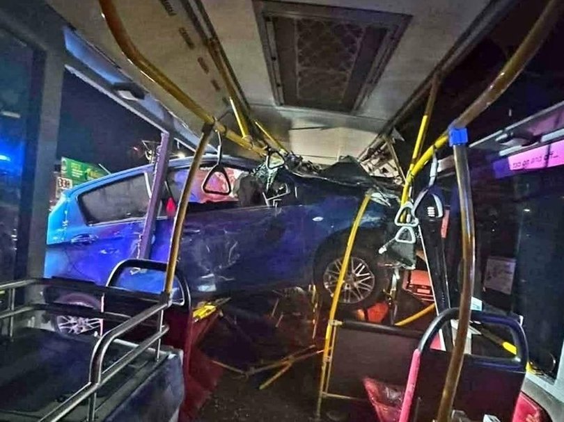 The car was wedged inside the empty bus.