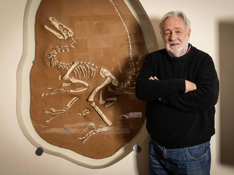 Geologist Greg Barnes in his office with his velociraptor fossil that was discovered in China.