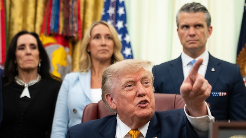 US President Donald Trump during an executive order signing ceremony this week as Pete Hegseth looks on.