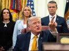 US President Donald Trump during an executive order signing ceremony this week as Pete Hegseth looks on