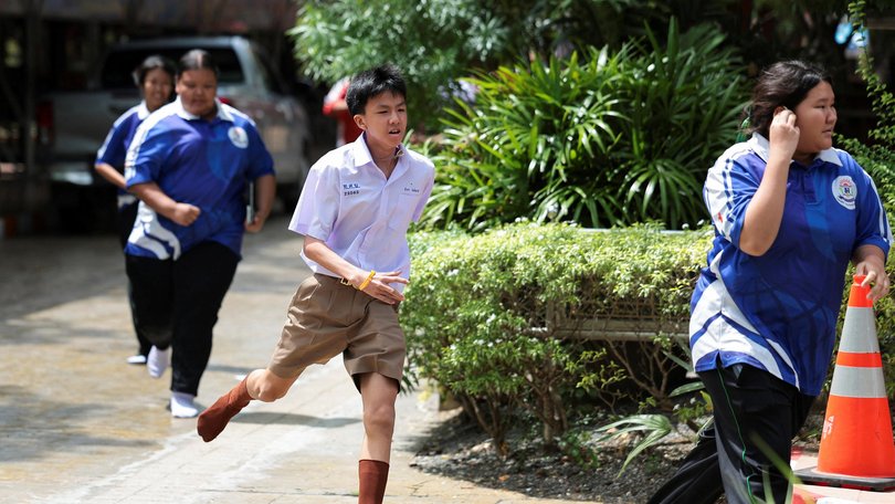 Students run as they evacuate from Debsirin Nonthaburi School.
