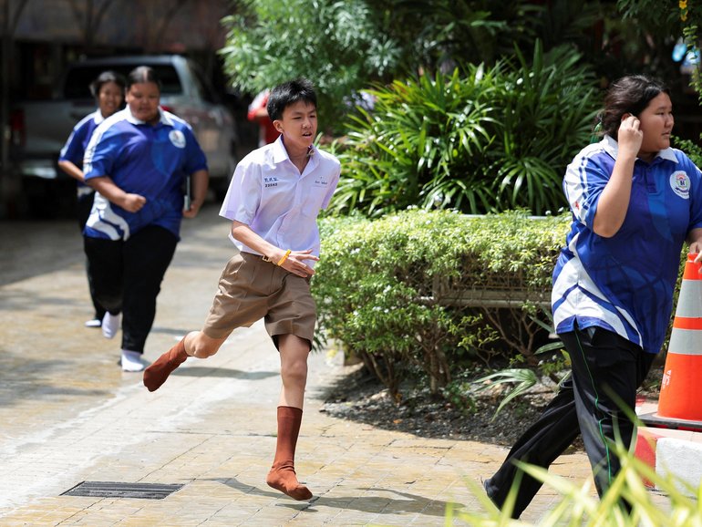 Students run as they evacuate from Debsirin Nonthaburi School.
