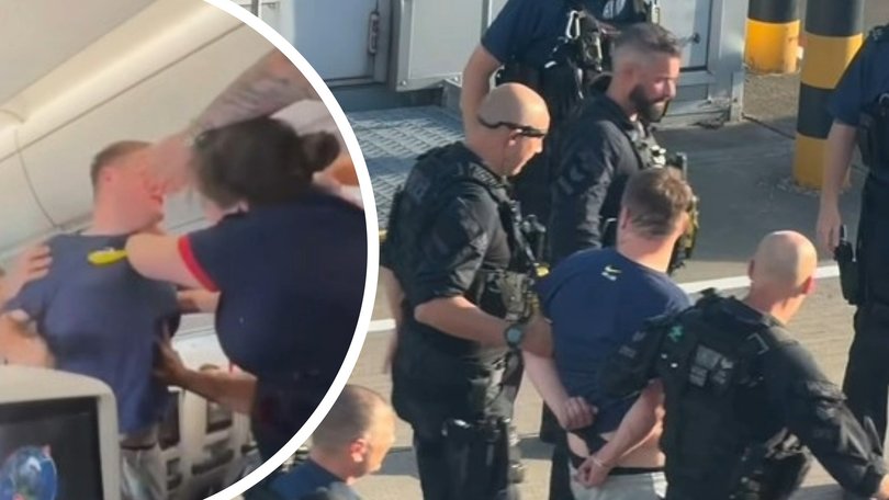 A disruptive passenger has been dragged off a plane in handcuffs after his violent outburst forced the pilot to ground the flight.