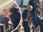 A disruptive passenger has been dragged off a plane in handcuffs after his violent outburst forced the pilot to ground the flight.