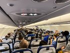 A man is facing an attempted murder charge after allegedly trying to open an emergency exit door mid-air.