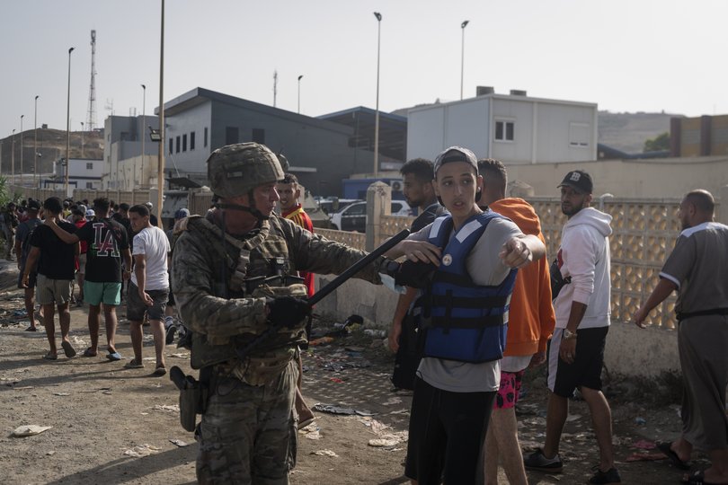 A Spanish soldier guards migrants going back to Morocco after crossing the border between Spain and Morocco on July 31, 2026 in Ceuta, Spain. 