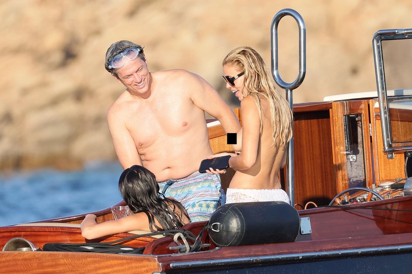 The 29-year-old bared her chest as she soaked up the sun on a family holiday in Sardinia, Italy on Sunday.