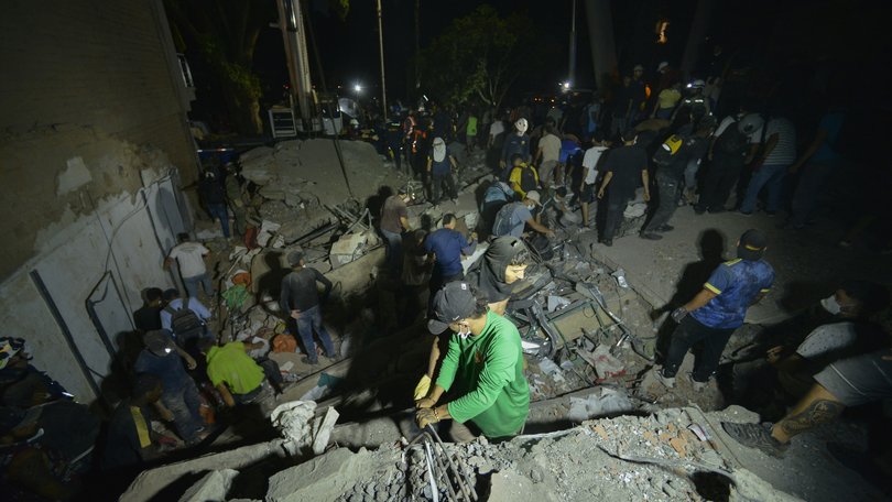 Volunteers help with debris removal at a collapsed building at Simón Bolívar square in downtown Pereira after a magnitude 7.4 earthquake struck Colombia.