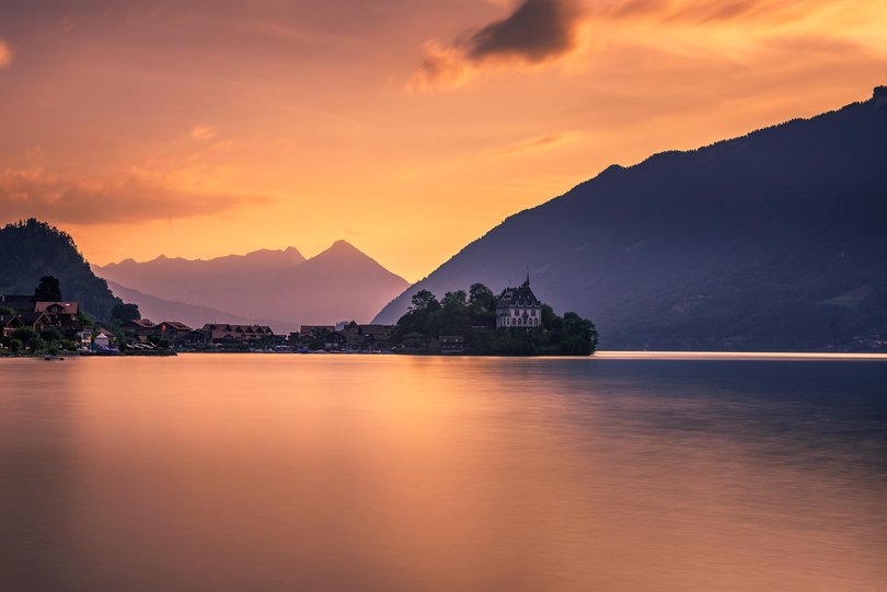 Sunset above Iseltwald peninsula and forme castle in Switzerland, now Rehabilitation Center of Seeburg.