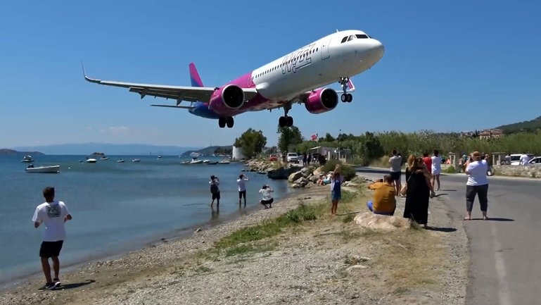 As passenger jets land at the airport, they skim over the heads of nearby onlookers.