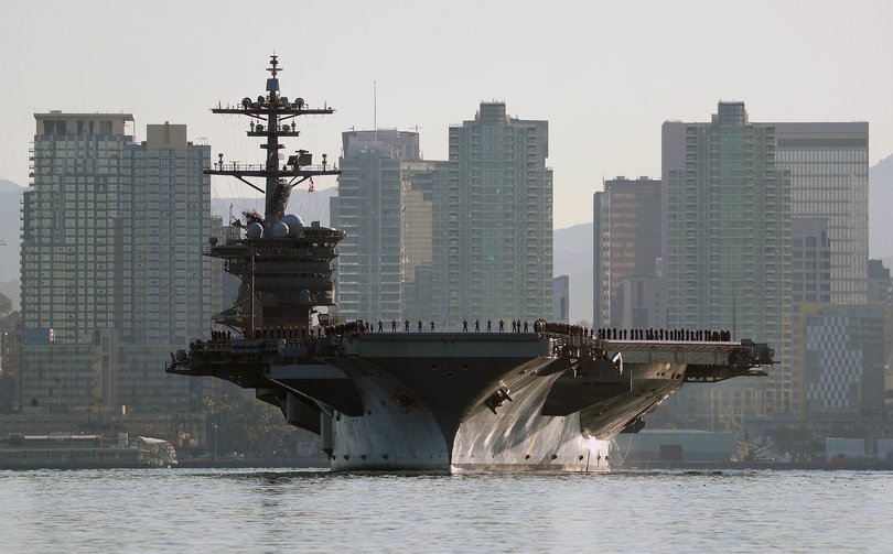 Sailors and marines line the deck of the aircraft carrier USS Abraham Lincoln (CVN-72) as it deploys from San Diego.