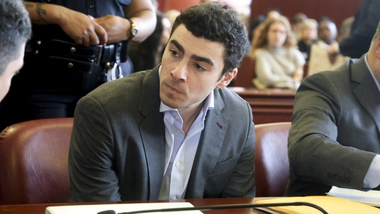 FILE — Luigi Mangione, charged in the murder of UnitedHealthcare chief executive Brian Thompson, confers with one of his attorneys at a pretrial hearing in State Supreme Court in Manhattan, Dec. 11, 2025. Mangione is expected to plead guilty to federal stalking charges on Aug. 14, 2026. A separate murder trial is set to begin next month. (Jefferson Siegel/The New York Times)