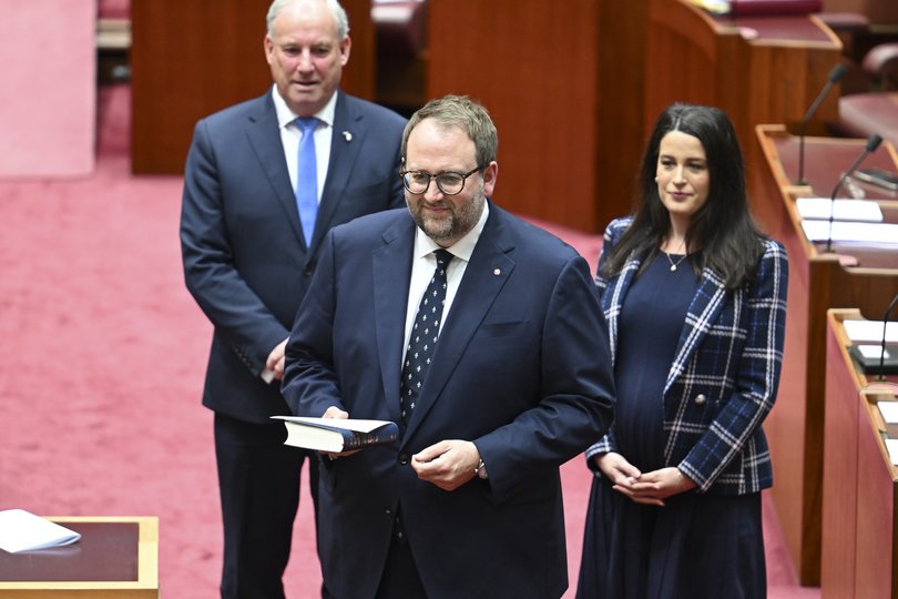 Newly appointed Tasmanian Liberal Senator Chris Gatenby is escorted into the Senate chamber by Senator Richard Colbeck and Liberal Senator Claire Chandler at Australian Parliament House.