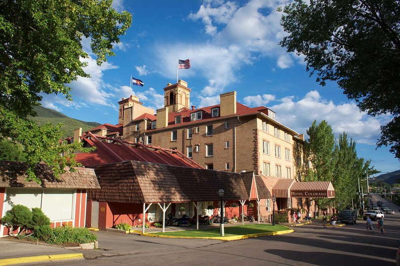 The grand Hotel Colorado was opened in 1893 and still looks the part — red brick, arched windows, taxidermy, chandeliers, a lobby pitched somewhere between hunting lodge and faded palace.