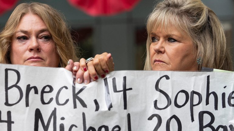 Victoria Hinks (L) and Lori Schott (R) hold hands as family members of young people who allegedly died from the impacts of social media demonstrate outside the Meta trial in California.