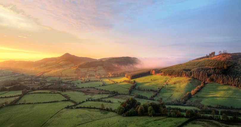 An aerial view of A foggy sunrise over Tipperary mountains.