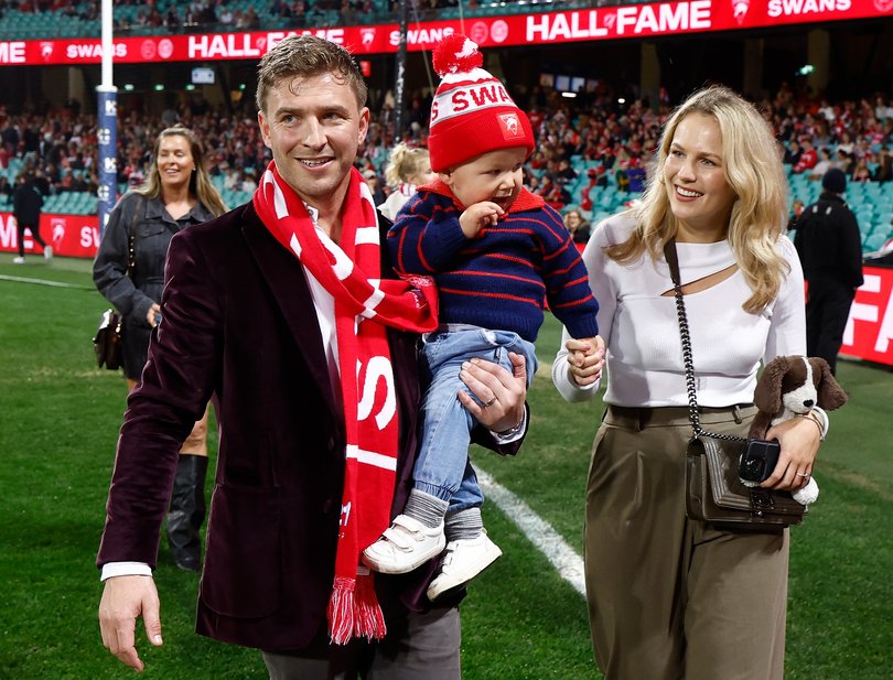 Kieren Jack completes a lap of honour with son Alfred and wife Charlotte.
