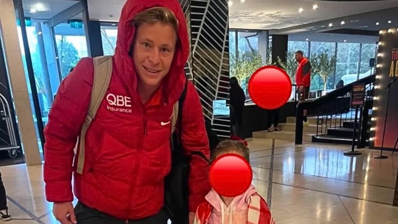Heeney poses with a 5-year-old fan while Dean Cox can be seen talking to a woman in the background.