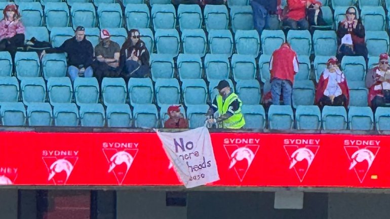 The Swans fan’s banner was removed by security during the AFLW game.