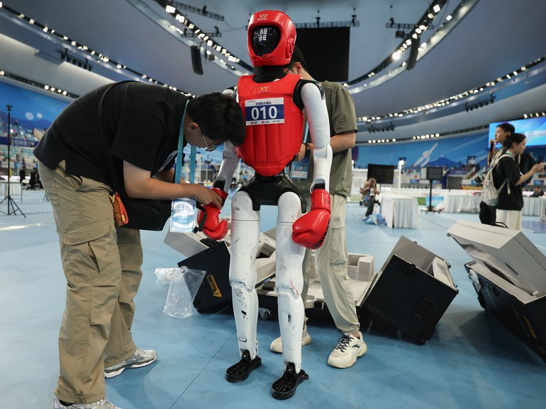 BEIJING, CHINA - AUGUST 24: Technical prepare the humanoid robots in the lightweight combat event during the 2nd World Humanoid Robot Games at National Speed Skating Oval on August 24, 2026 in Beijing, China. The second World Robot Games will be held in Beijing from August 22nd to 26th.  (Photo by Lintao Zhang/Getty Images)