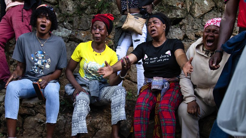  A body lies on the ground as people react following overnight violence in Kenscoff, a neighbourhood near Port-au-Prince, Haiti.