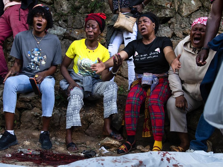  A body lies on the ground as people react following overnight violence in Kenscoff, a neighbourhood near Port-au-Prince, Haiti.