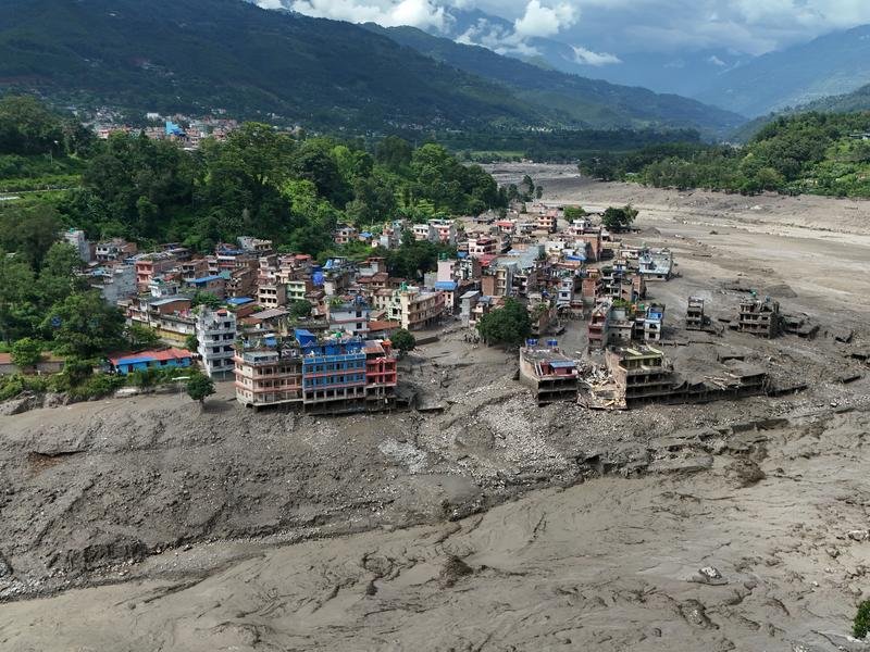 Damaged houses stand precariously on the banks of the Trishuli river after flash floods in Nepal. (EPA PHOTO)