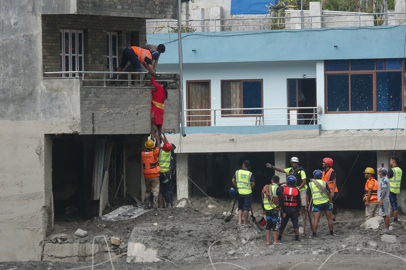 Security personnel rescue flood victims.